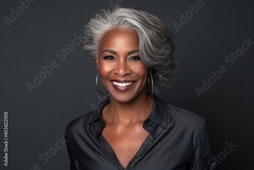 photo of a profole of a 45-year-old African woman with a fashionable haircut in a plain blouse, eye contact, smile, dark background photo