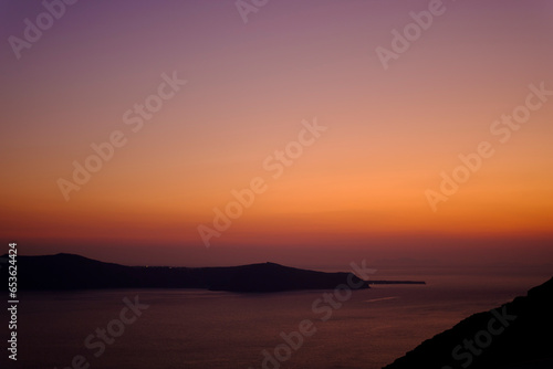 Orange and purple sunset sky in a coastal shore landscape in Santorini, Greece