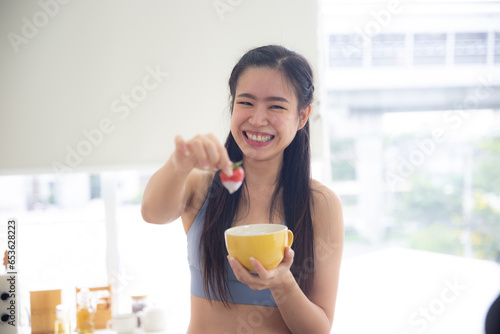 Healthy and Sportive woman eating apple, Pretty girl wearing sportswear preparing healthy food for breakfast after training