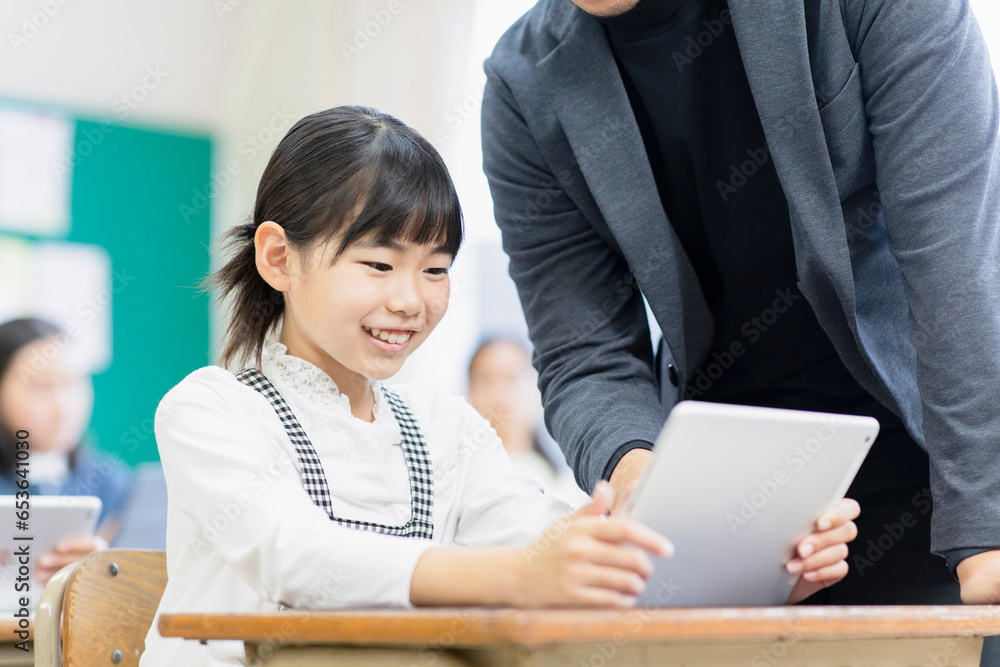 タブレットPCで勉強をする小学生と先生