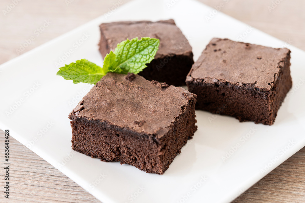 Chocolate brownie portion on wooden table. Close up