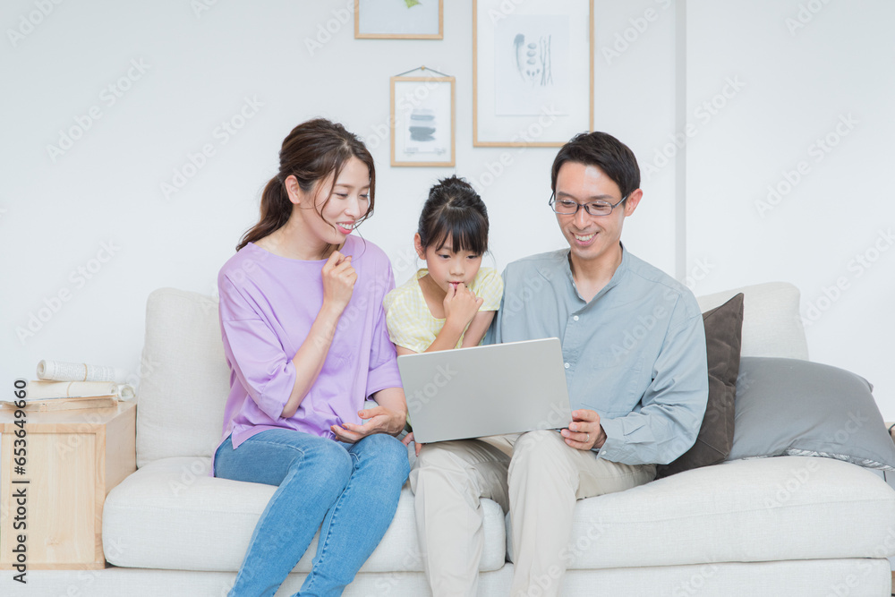 リビングでパソコンを見ながらくつろぐ親子 リビングでパソコンを見ながらくつろぐ親子