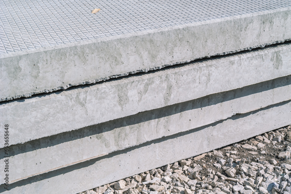 Reinforced concrete slabs for road construction are stacked. Solid
