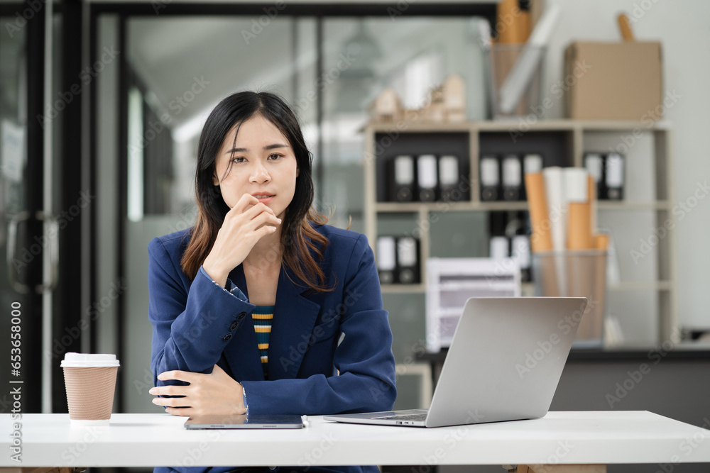Female asian sitting at the desk, looking to camera. Female asian sitting at the desk, looking to camera.