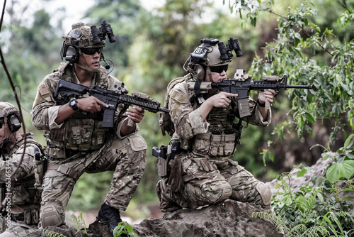 Print op canvas Military army soldiers tactical team, commando group moving cautiously in forest area, kneeling and looking around, covering comrades, controlling sectors