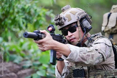 Military army soldiers tactical team, commando group moving cautiously in forest area, kneeling and looking around, covering comrades, controlling sectors. Commander showing halt or stop hand signal