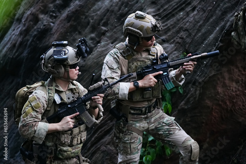 Military army soldiers tactical team, commando group moving cautiously in forest area, kneeling and looking around, covering comrades, controlling sectors. Commander showing halt or stop hand signal