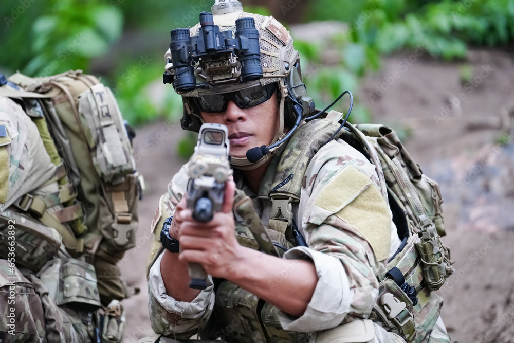 Fototapeta premium Military army soldiers tactical team, commando group moving cautiously in forest area, kneeling and looking around, covering comrades, controlling sectors. Commander showing halt or stop hand signal