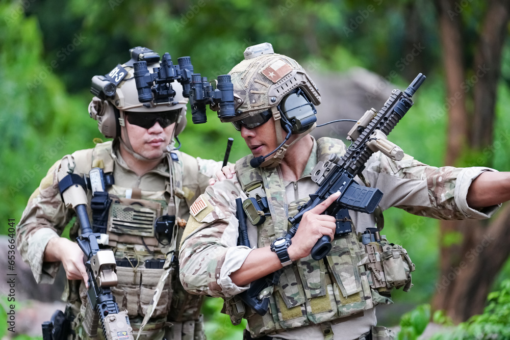 Military army soldiers tactical team, commando group moving cautiously in forest area, kneeling and looking around, covering comrades, controlling sectors. Commander showing halt or stop hand signal Military army soldiers tactical team, commando group moving cautiously in forest area, kneeling and looking around, covering comrades, controlling sectors. Commander showing halt or stop hand signal