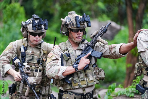 Fototapeta Military army soldiers tactical team, commando group moving cautiously in forest area, kneeling and looking around, covering comrades, controlling sectors