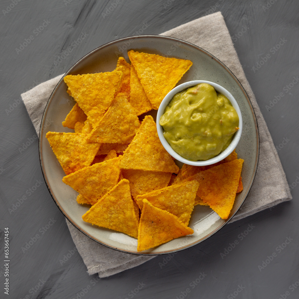 Homemade Guacamole with Tortilla Chips on a Plate, top view. Flat lay, overhead, from above. Homemade Guacamole with Tortilla Chips on a Plate, top view. Flat lay, overhead, from above.