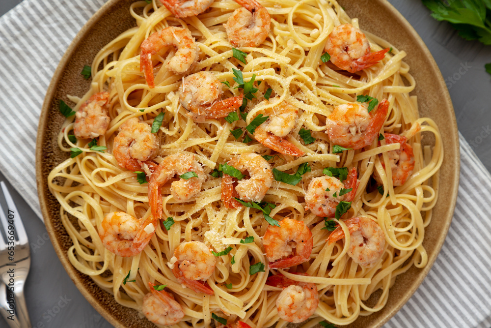 Baked Shrimp Scampi Linguine Pasta with Parsley on a Plate, top view. Flat lay, overhead, from above. Baked Shrimp Scampi Linguine Pasta with Parsley on a Plate, top view. Flat lay, overhead, from above.