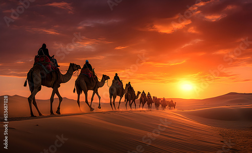 A caravan of camels walking through the desert at sunset.