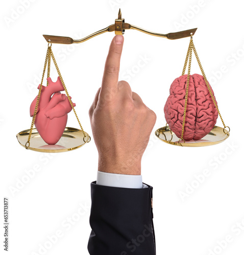 Heart and brain balance. The man holds the scales with his finger and balances the heart and brain. Photo manipulation. Isolated white background. (ID: 653713877)