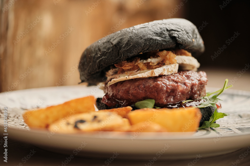 Savor the flavors: A succulent black bun burger with layers of taste that create a symphony in every bite. Savor the flavors: A succulent black bun burger with layers of taste that create a symphony in every bite.