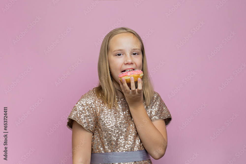 Happy child biting delicious donut against pink studio wall banner background Happy child biting delicious donut against pink studio wall banner background