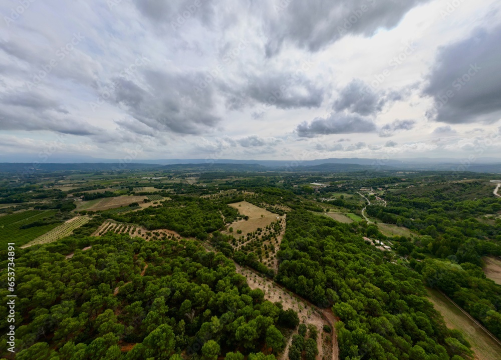 Aerial Panorama between Vaugines and Cucuron: Cloudy Skies Over Ancient and New Forests in PACA, Provence – A Drone’s View