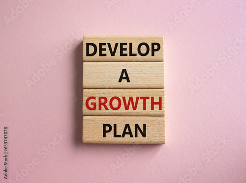 Develop a growth mindset symbol. Wooden blocks with words Develop a growth mindset. Beautiful pink background. Business concept. Copy space