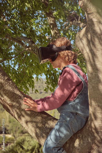 Boy in VR headset sitting on tree © ADDICTIVE STOCK CORE