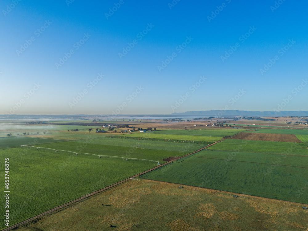 Distant mist on horizon with aerial view over agricultural farm land