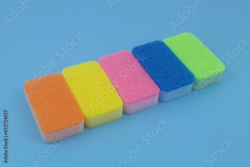 Different sponges in a row on blue background.