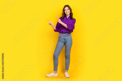 Full length photo of stunning positive person insicate fingers empty space ad isolated on yellow color background