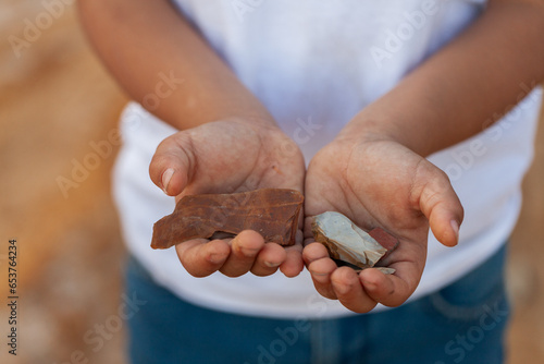 First Nation Australian child holding aboriginal artefact stones in hands photo