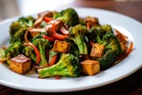 stir-fried veggies with tempeh served on a white dish