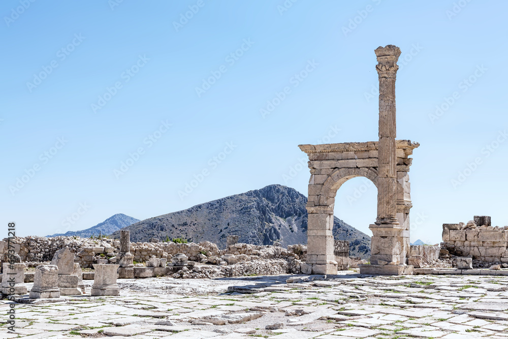 Triumphal arch and honorary column at Upper Agora in ancient city of Sagalassos. Aglasun, Budur, Turkey