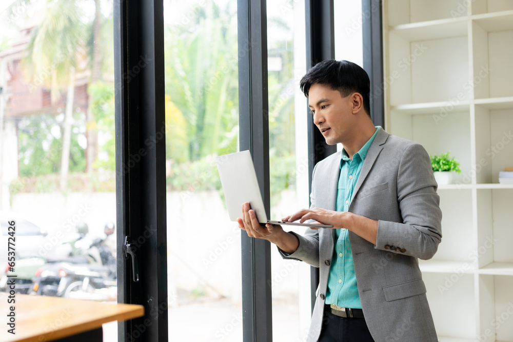Asian businessman working at office with laptop and documents on table Work in the workplace, business documents, financial planning concepts Asian businessman working at office with laptop and documents on table Work in the workplace, business documents, financial planning concepts