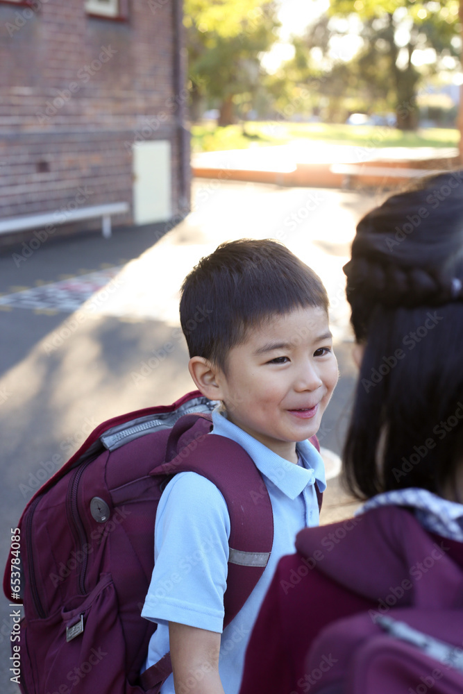 Two happy children talking in the playground at school Two happy children talking in the playground at school