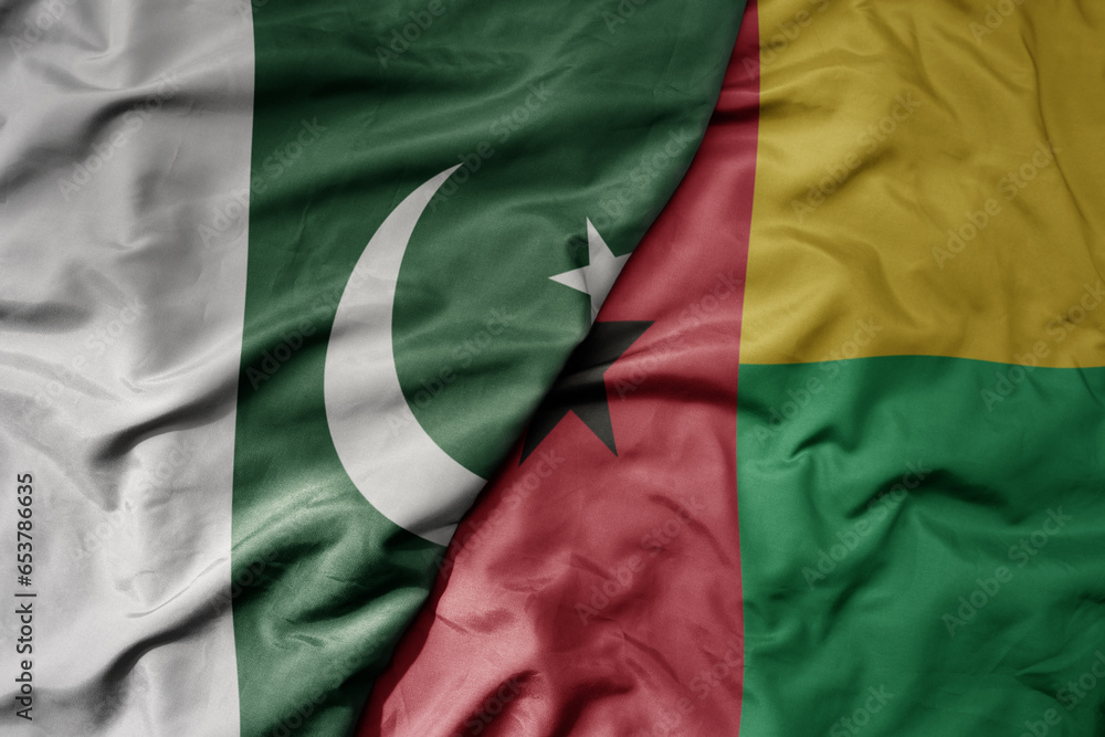 big waving realistic national colorful flag of pakistan and national flag of guinea bissau .