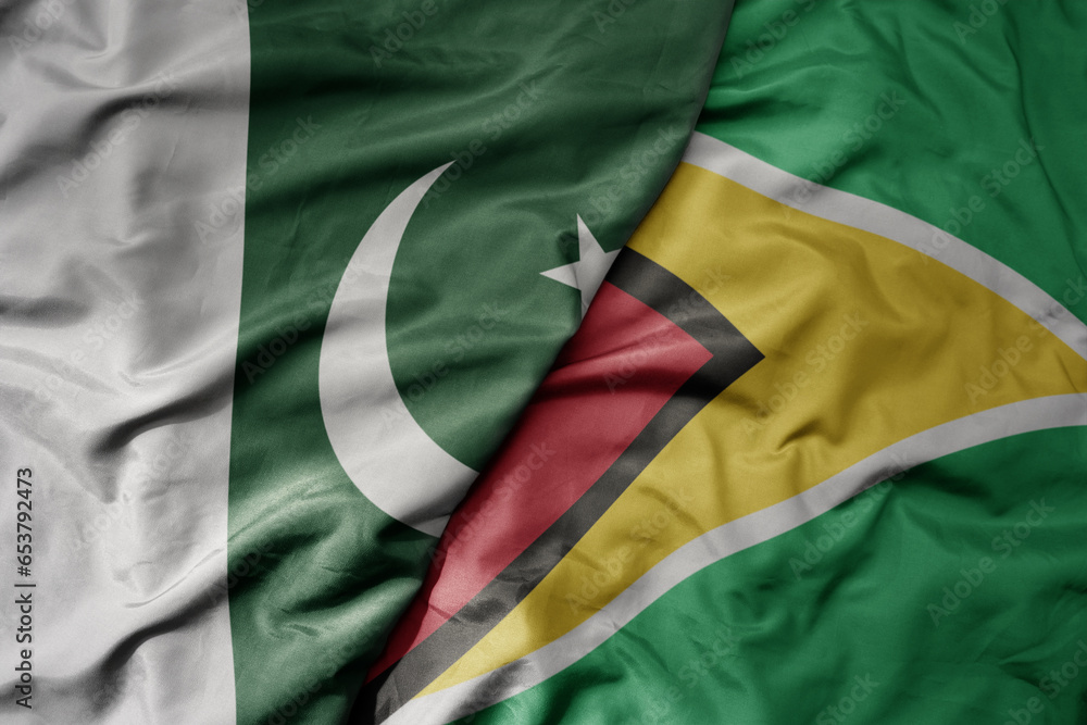 Obraz premium big waving realistic national colorful flag of pakistan and national flag of guyana .