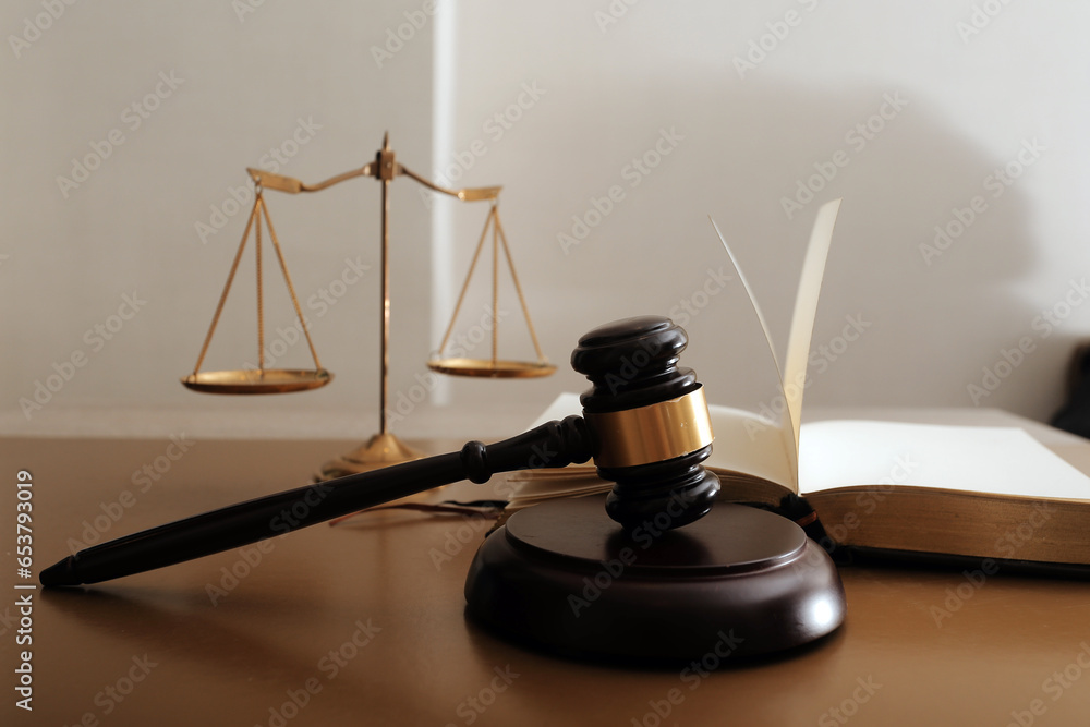 Business and lawyers discussing contract papers with brass scale on desk in office. Law, legal services, advice, justice and law concept picture with film grain effect Business and lawyers discussing contract papers with brass scale on desk in office. Law, legal services, advice, justice and law concept picture with film grain effect