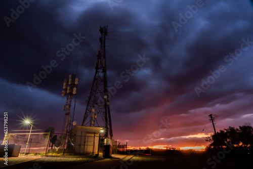 Low angle shot of telecom tower during overcast sunset