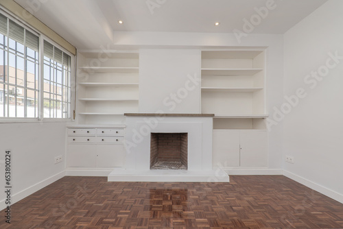 Living room in apartment with built-in fireplace and matching white wooden shelves