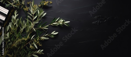 Top view of religious music on a black table adorned with olive branches and a Christian cross for Palm Sunday