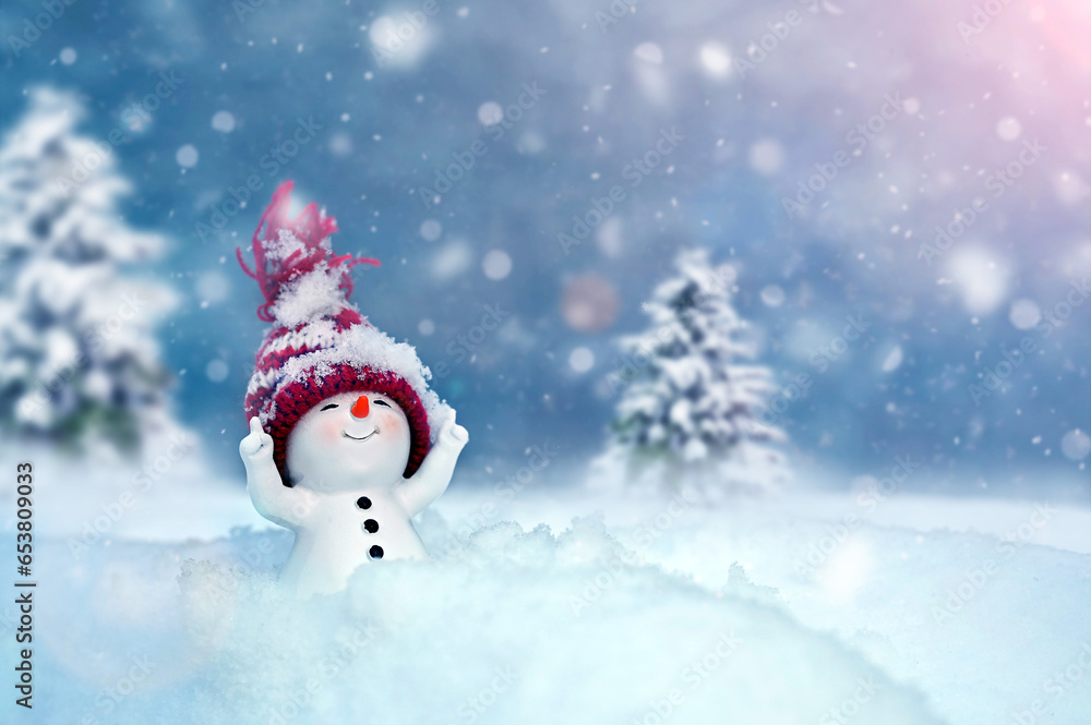 One little snowmen in caps on snow in the winter. Background with a funny snowman. Christmas card.