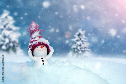 One little snowmen in caps on snow in the winter. Background with a funny snowman. Christmas card.