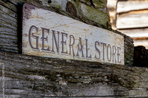 Billede på lærred Retro vintage weathered rustic wooden general store sign hanging on exterior wal