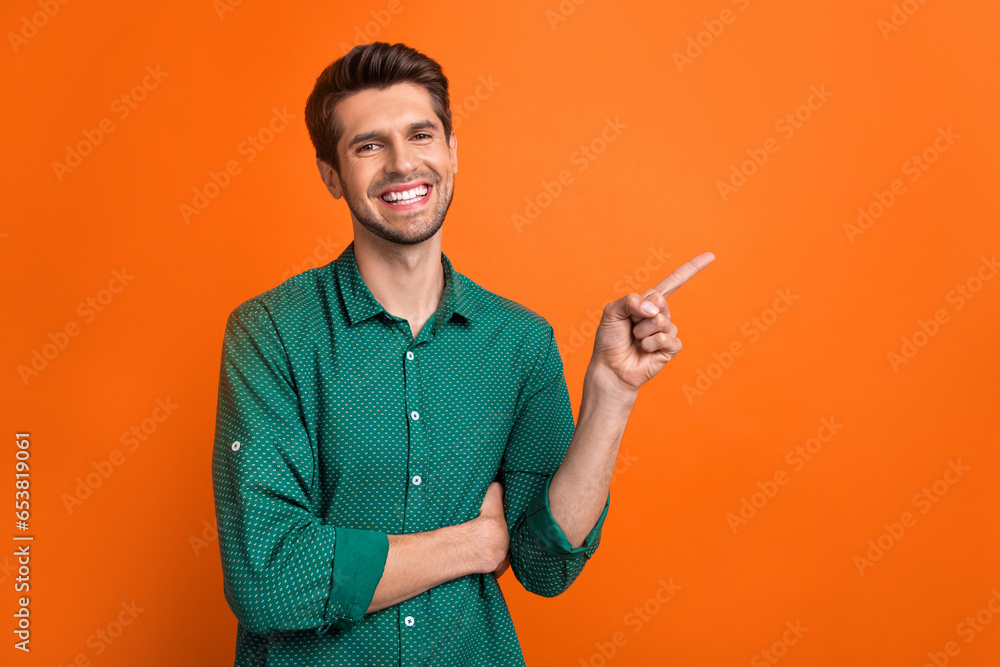 Photo of young man brunet wear orange stylish shirt direct finger mockup presentation check list to do isolated on orange color background Photo of young man brunet wear orange stylish shirt direct finger mockup presentation check list to do isolated on orange color background