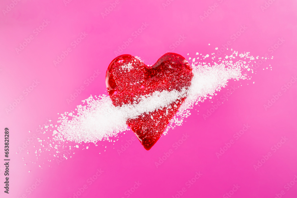 Red blood splatter in form of a heart mixed with sugar crystals on magenta background, soft focus close up, diabetes concept