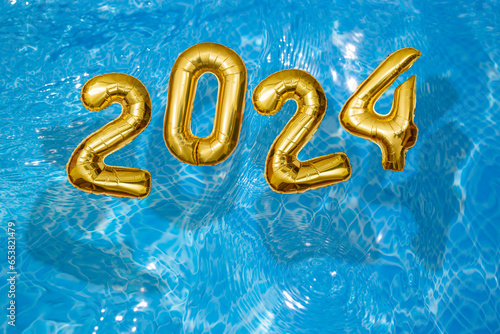 2024 Inflatable golden numbers on water ripples surface, happy new year with a swimming pool concept