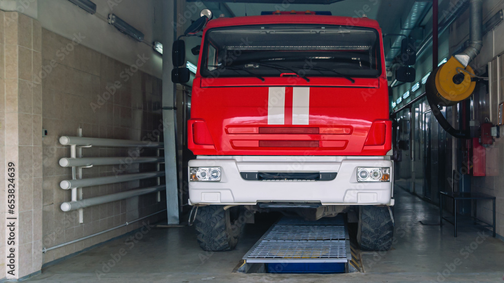 An all-terrain fire truck for the delivery of firefighters to the place of fire and the supply of extinguishing agent for extinguishing. A fire truck in a fire station. Emergency rescue service.
