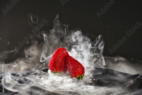 Fresh red strawberries with dry ice smoke and black background