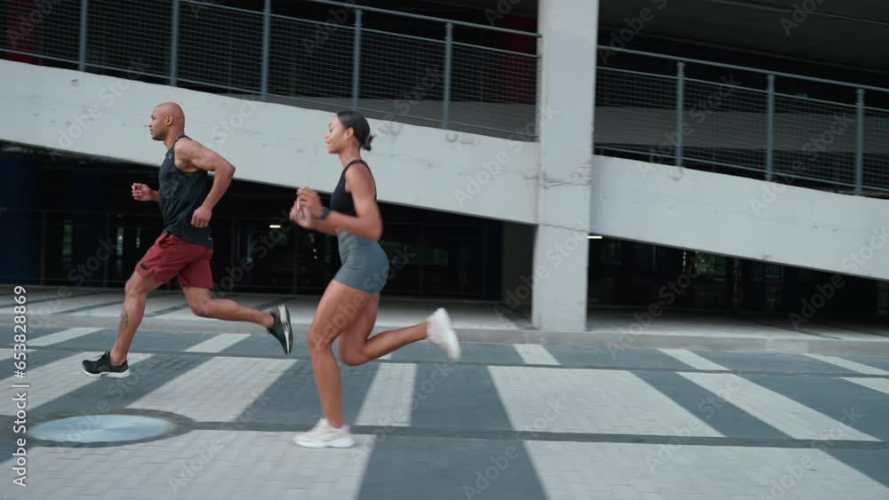 Serious athletic african couple running near parking lot outdoors Serious athletic african couple running near parking lot outdoors