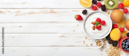 Top down view of a nutritious breakfast spread on a white wooden table including fruits yogurts oatmeal cereal smoothie bowl toasts and eggs