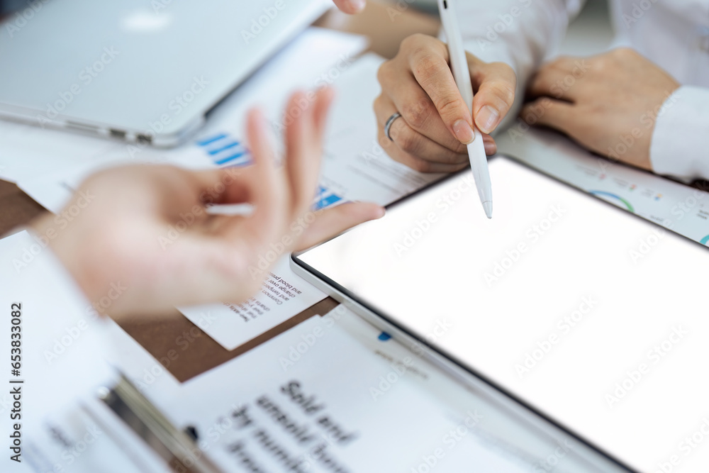 Businesswoman talks to colleague about strategy on tablet while meeting Businesswoman talks to colleague about strategy on tablet while meeting