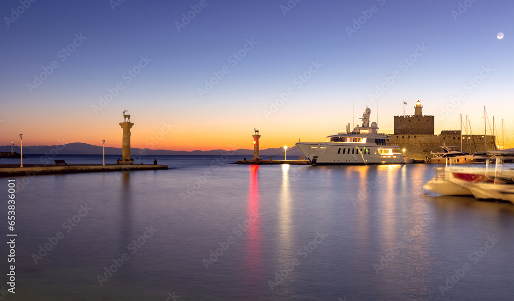 View of the city embankment in night lighting at dawn. Rhodes.