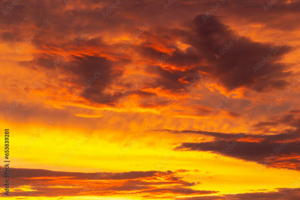 Mystical orange-yellow sky with clouds at sunset. Beauty and passion. Perfect background for your design